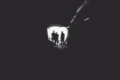 三个人站在隧道
